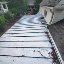 Roof with gutter debris and leaves, showcasing maintenance needs in residential setting.