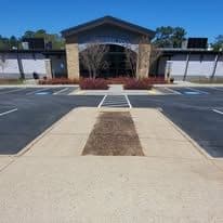 Modern building with landscaping and parking lot on a clear day.
