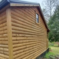 Wooden log cabin exterior with window and natural surroundings. Perfect for rustic building design.