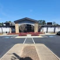 Modern building with landscaping, blue sky, and accessible parking spaces.
